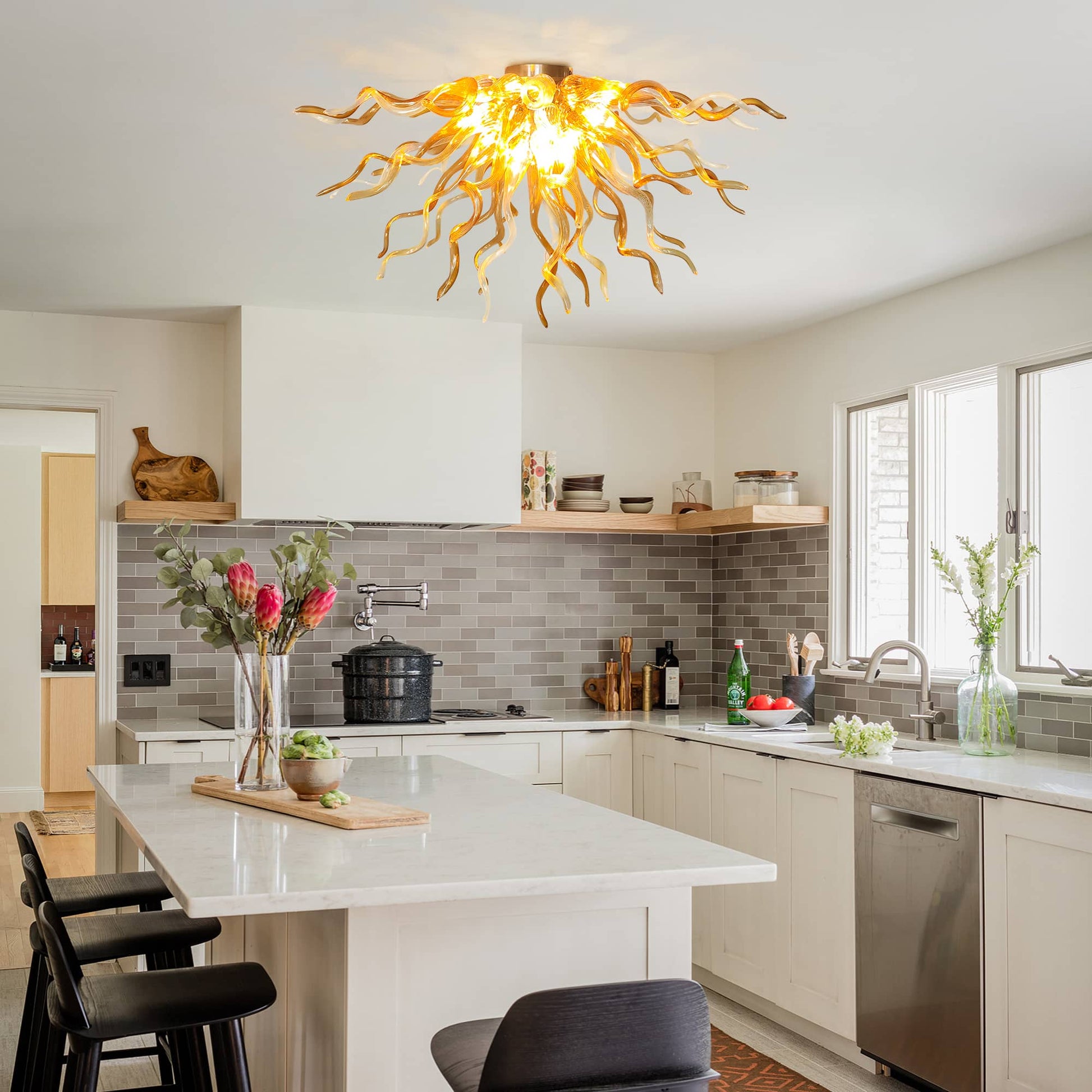 Modern open-concept kitchen lifestyle scene with the low-profile amber glass flush mount chandelier installed as premium ceiling lighting above a white marble kitchen island.