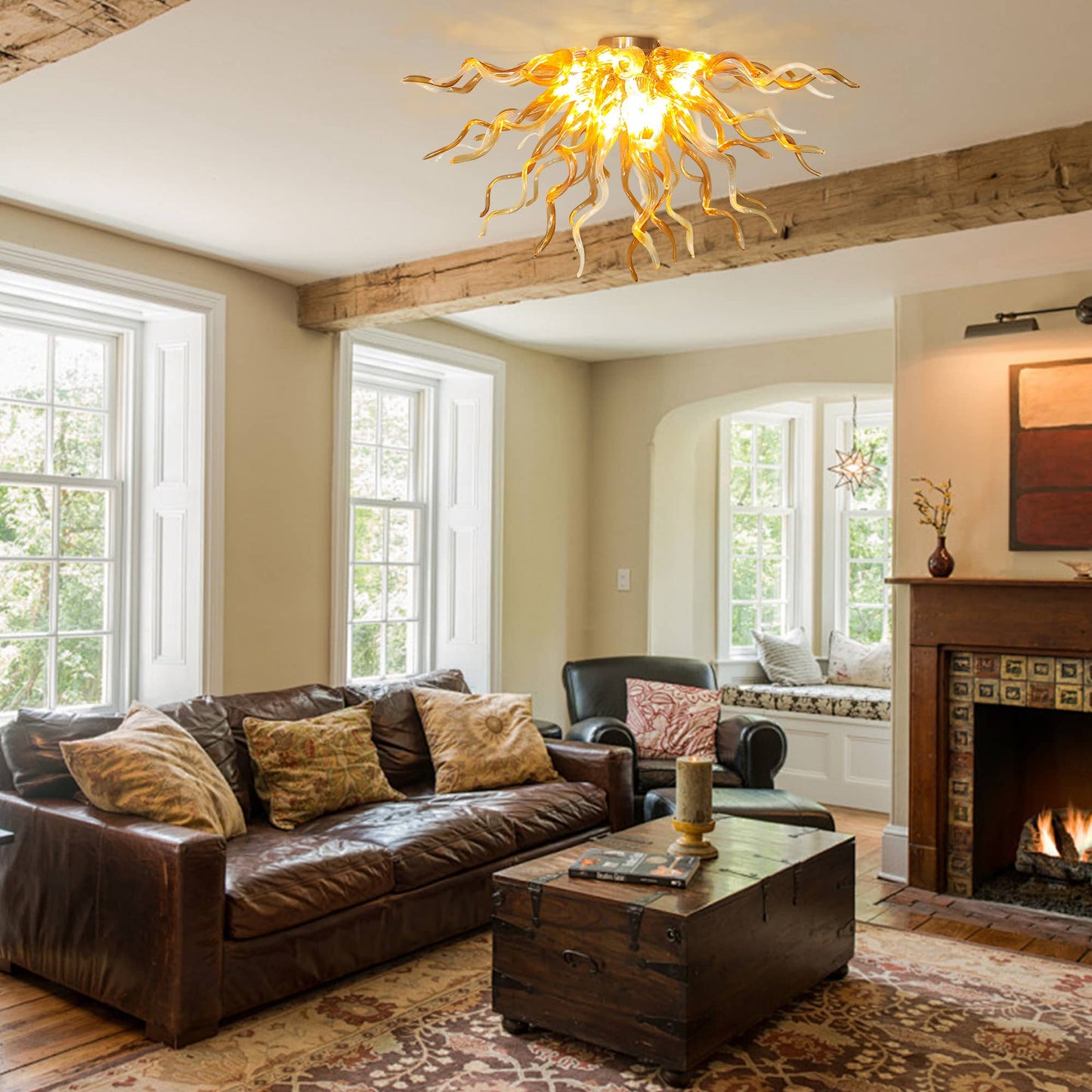Elegant rustic living room interior featuring the amber and champagne glass ceiling light fixture illuminating a space with a dark leather sofa, wooden beams, and a classic fireplace.