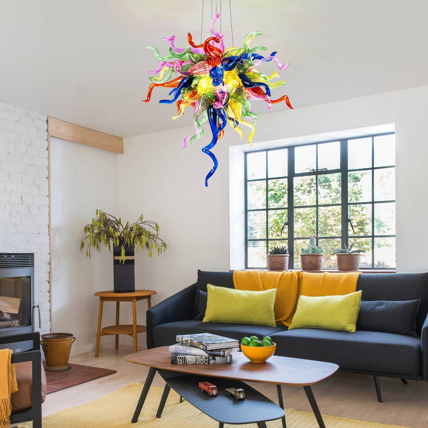 Modern small-sized multicolor glass chandelier adding a pop of color to a minimalist living room with a grey sofa.