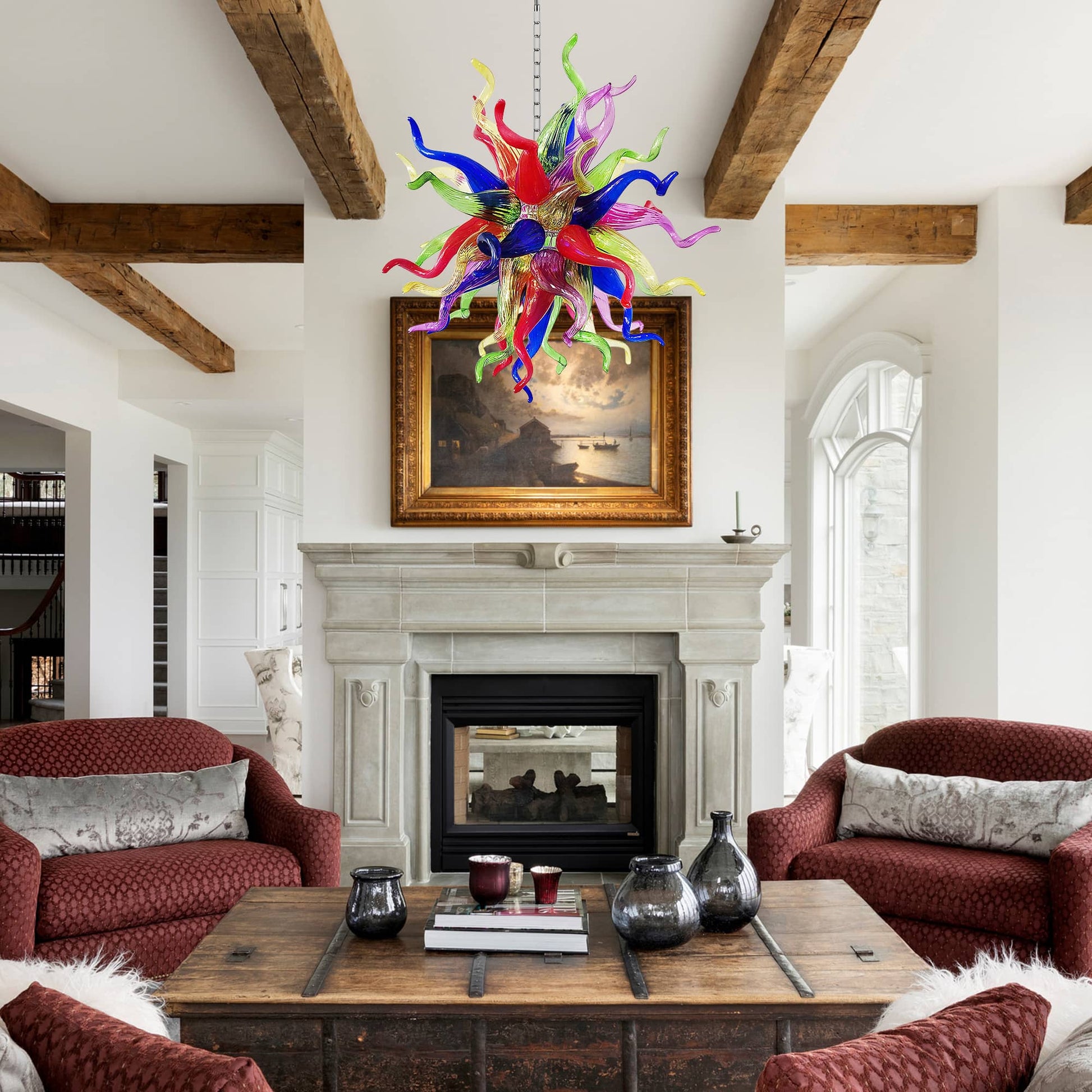 Luxurious interior with exposed wooden beams, red armchairs, and a stunning colorful Chihuly style blown glass chandelier.