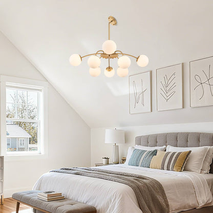 Modern gold bubble chandelier lighting a cozy bedroom in a sloped ceiling