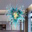 Luxury blue and teal hand-blown glass chandelier in a starburst pattern against a modern interior background.