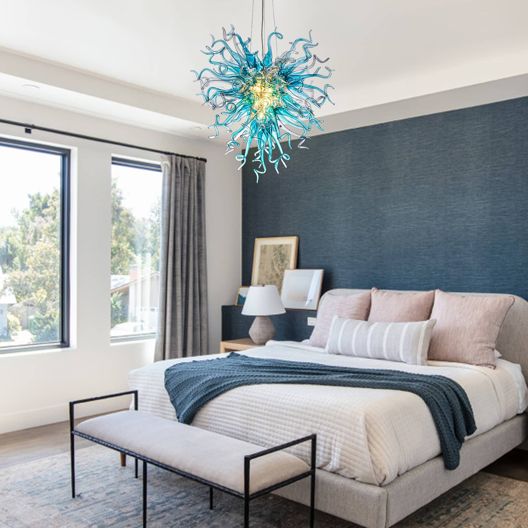 Large blue art glass chandelier providing a striking artistic contrast in a minimalist master bedroom.