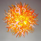 Detailed sculptural view of the orange and white glass tendrils, highlighting the fiery organic flow of the artisan lighting fixture.