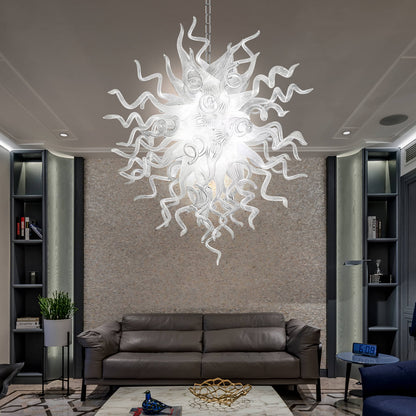 Chihuly style blown glass chandelier hanging in a living room with a brown sofa and bookshelves.