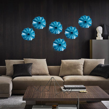 A dramatic cluster of seven vibrant blue blown glass wall flowers used as an artistic wall decor in a contemporary living room.