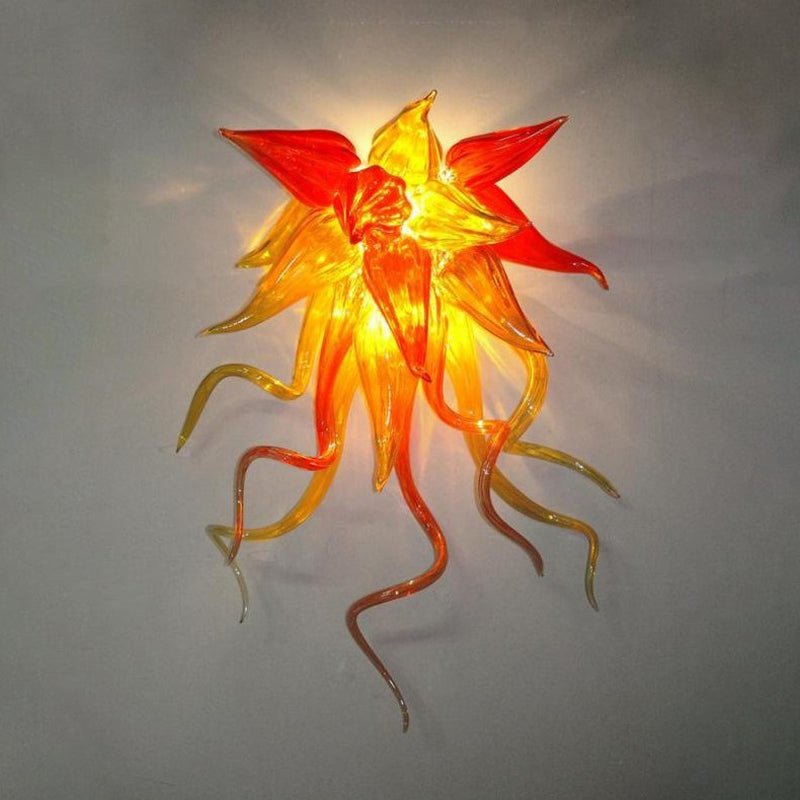Modern sculptural wall light with vibrant red and orange flame-shaped glass elements.