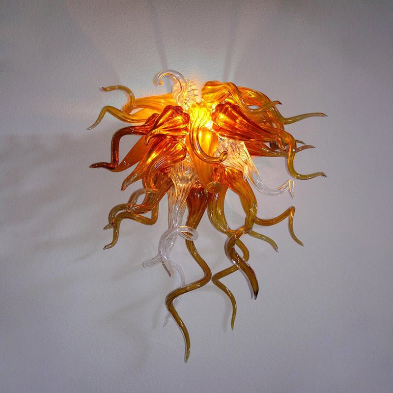 Warm amber and orange hand-blown glass wall lamp radiating a cozy, artistic glow.