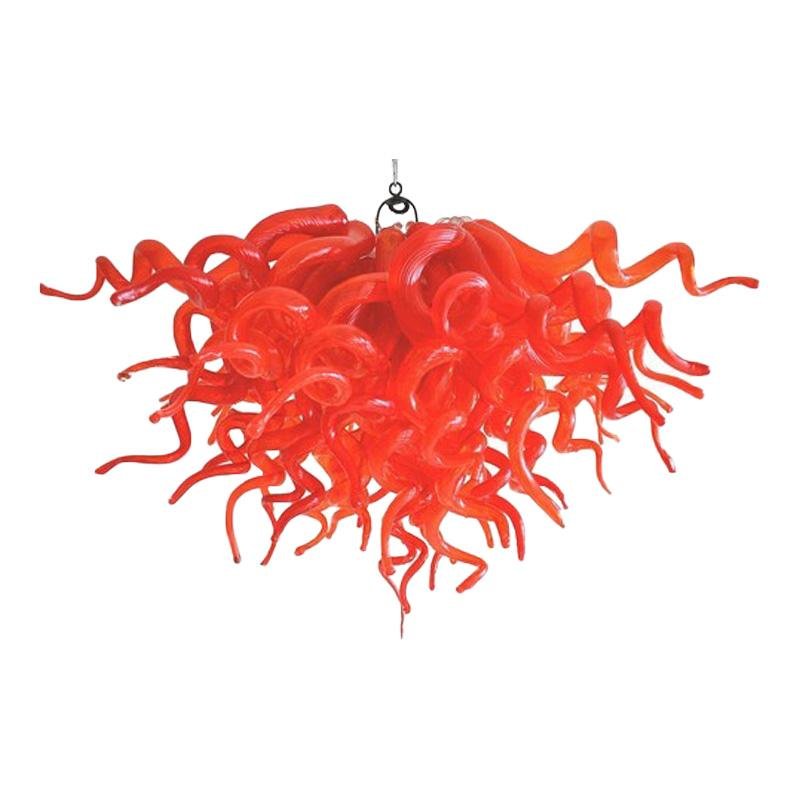 Detailed view of a vibrant red artisan blown glass chandelier featuring organic, twisted glass tendrils.