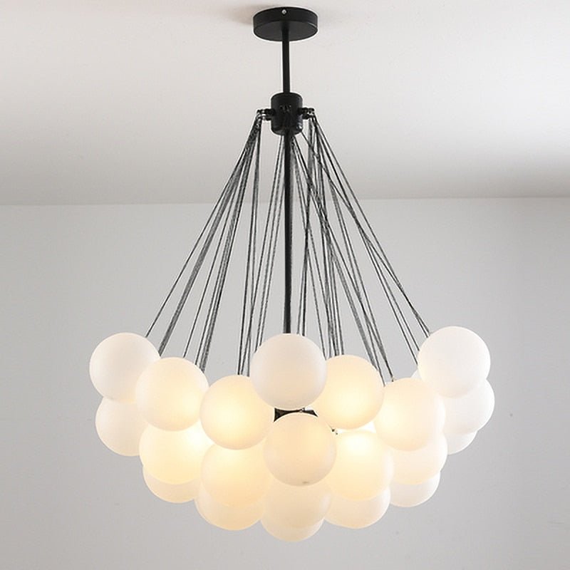 Modern Nordic chandelier featuring a large cluster of milky white frosted glass balls with a black minimalist frame.