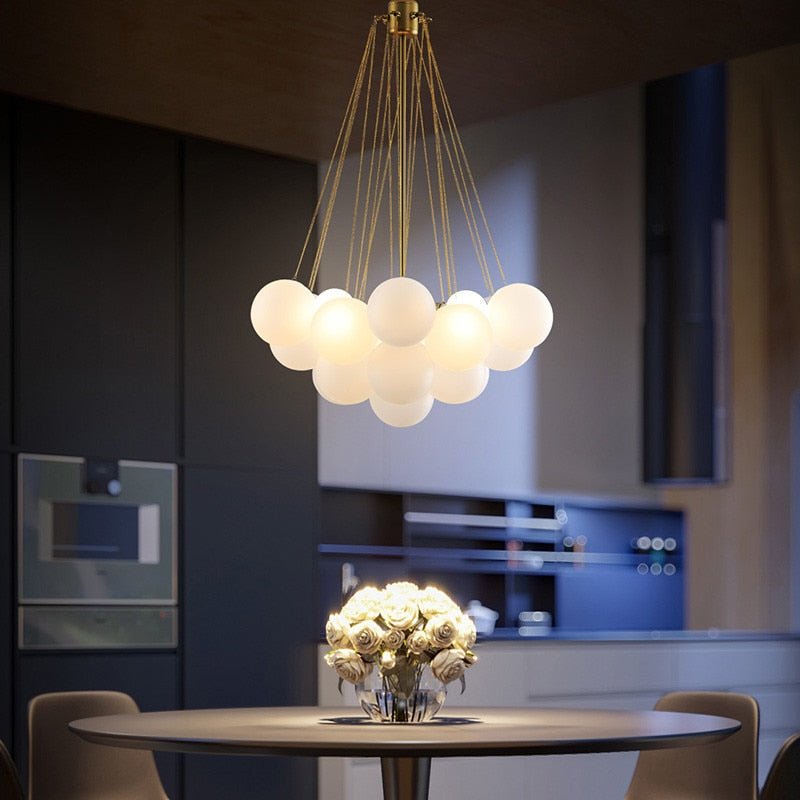 Contemporary dining area with a glowing white globe cluster light creating a cozy atmosphere at night.