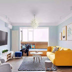 Contemporary airy living room with a bright yellow sofa, centered by a white sculptural glass pendant light for a playful modern vibe.