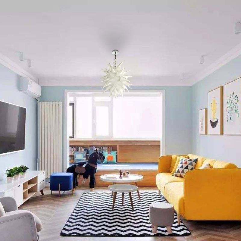 Contemporary airy living room with a bright yellow sofa, centered by a white sculptural glass pendant light for a playful modern vibe.