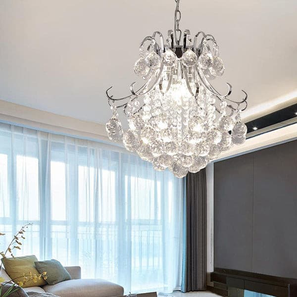 Large crystal ball chandelier glowing in a modern living room with neutral decor.