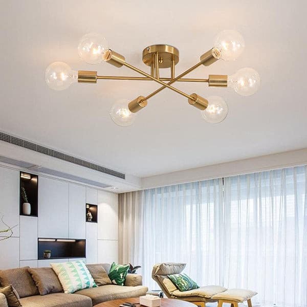 Mid-century modern 6-light Sputnik chandelier in brushed brass hanging in a bright living room.