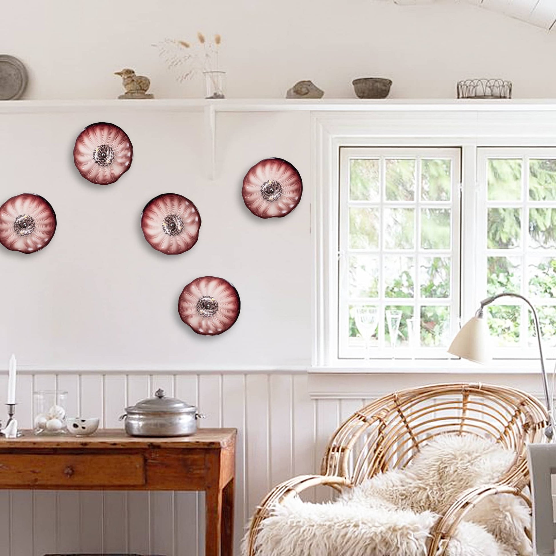 A cluster of five small brown glass wall plates used as decorative wall art in a sunlit breakfast nook.