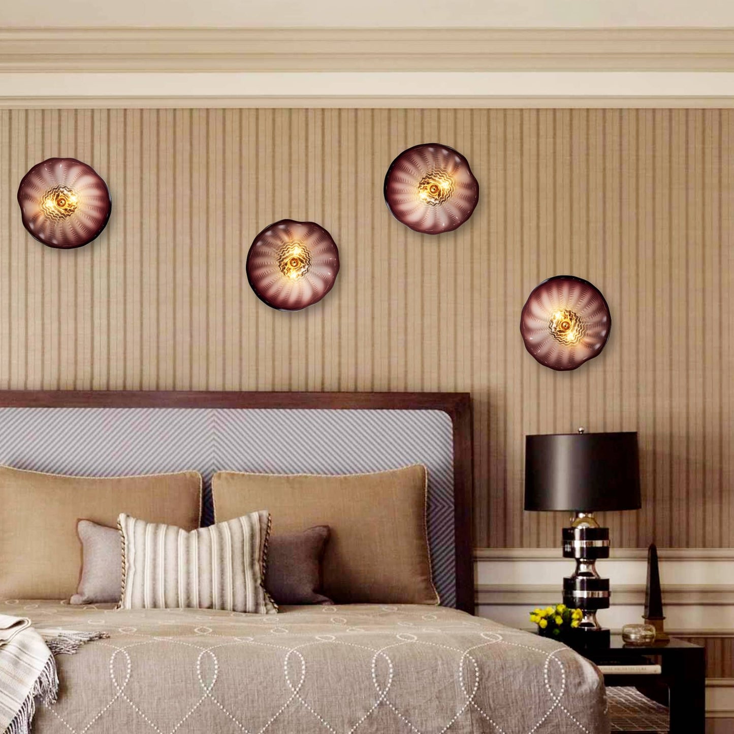 Four glowing glass wall flower lights mounted above a bed headboard, creating a warm and cozy atmosphere.