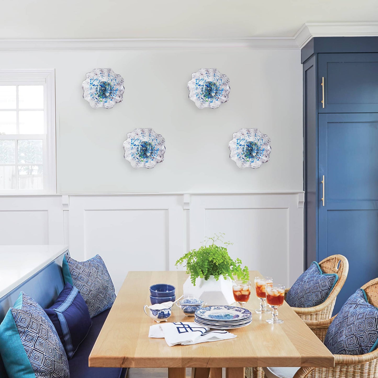 A line of four leopard texture glass wall lights mounted in an elegant dining room with blue cabinetry.
