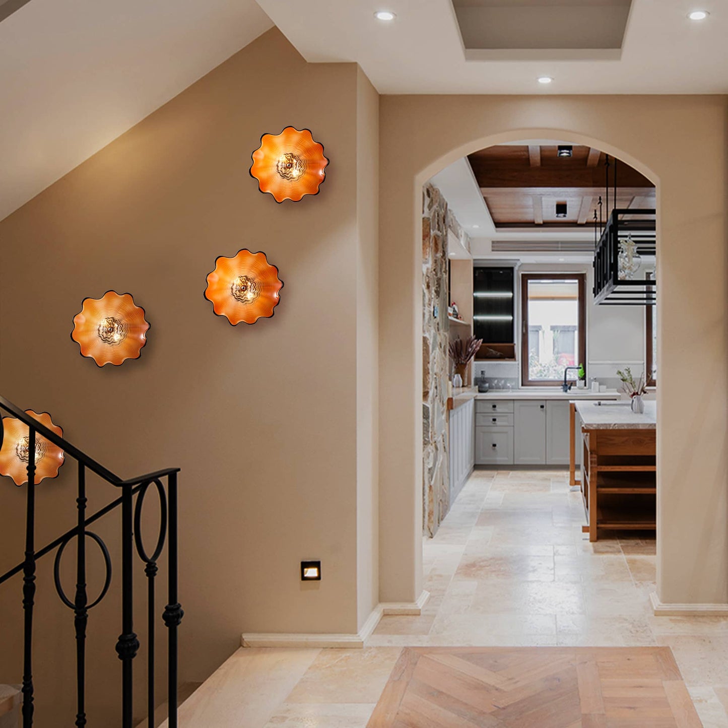 Three glowing orange artisanal glass plates mounted along a neutral-toned hallway near a staircase.
