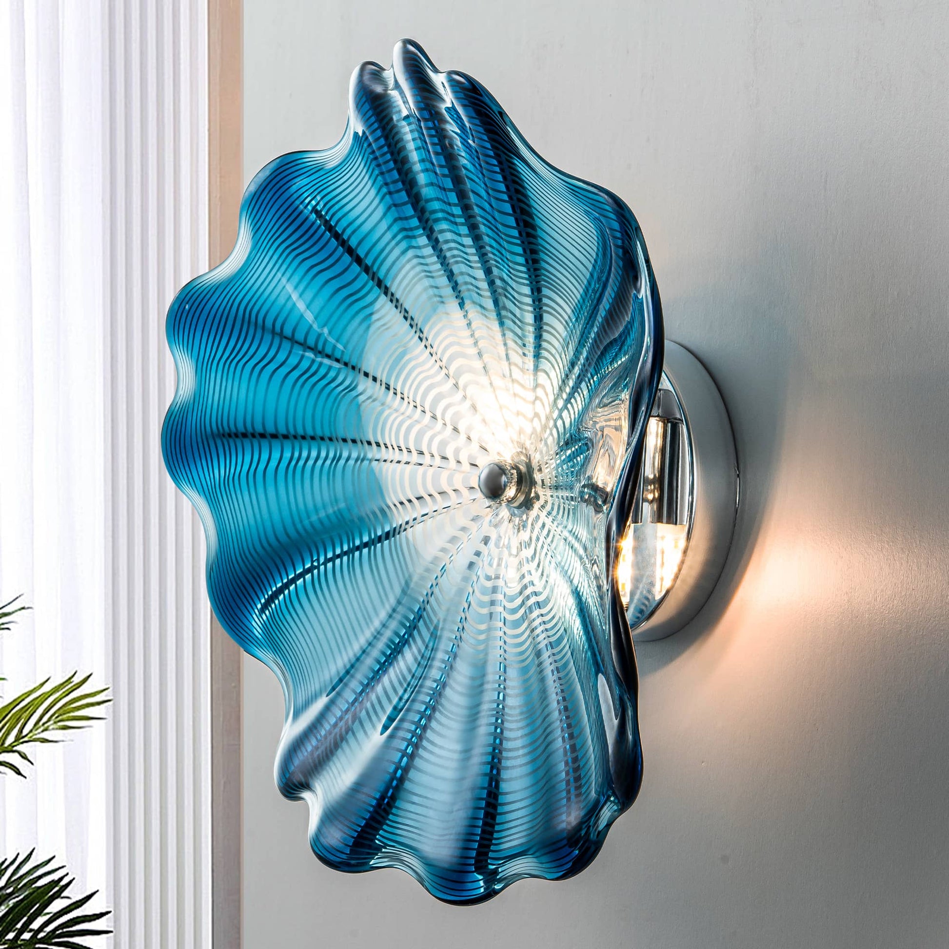 Side view of a blue Murano style glass wall flower showing the backlit LED glow and mounting bracket.