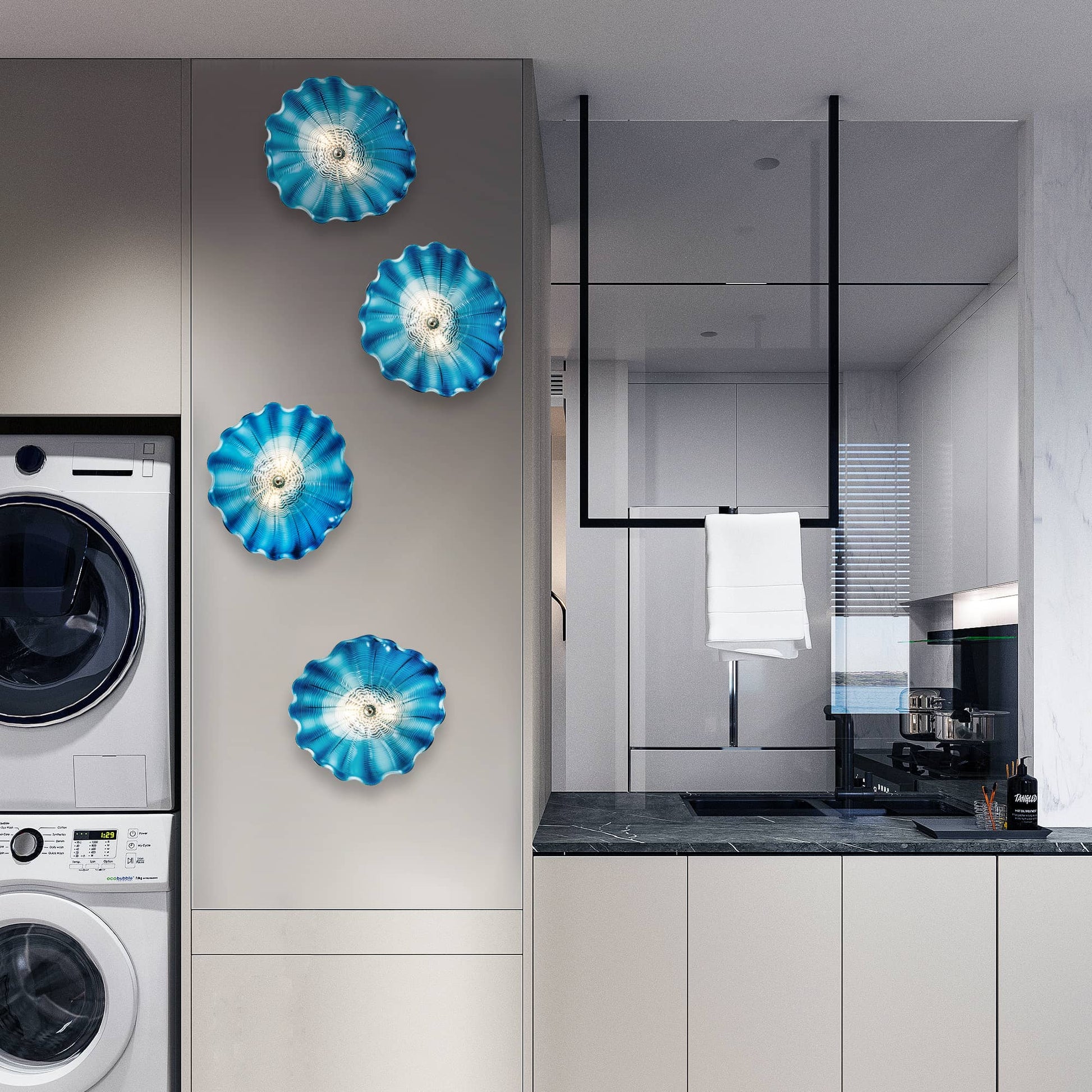 Vertical arrangement of five blue glass wall art plates in a modern laundry room setting.