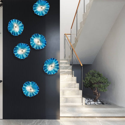 Stunning installation of blue glass wall art lights on a dark accent wall next to a modern staircase.