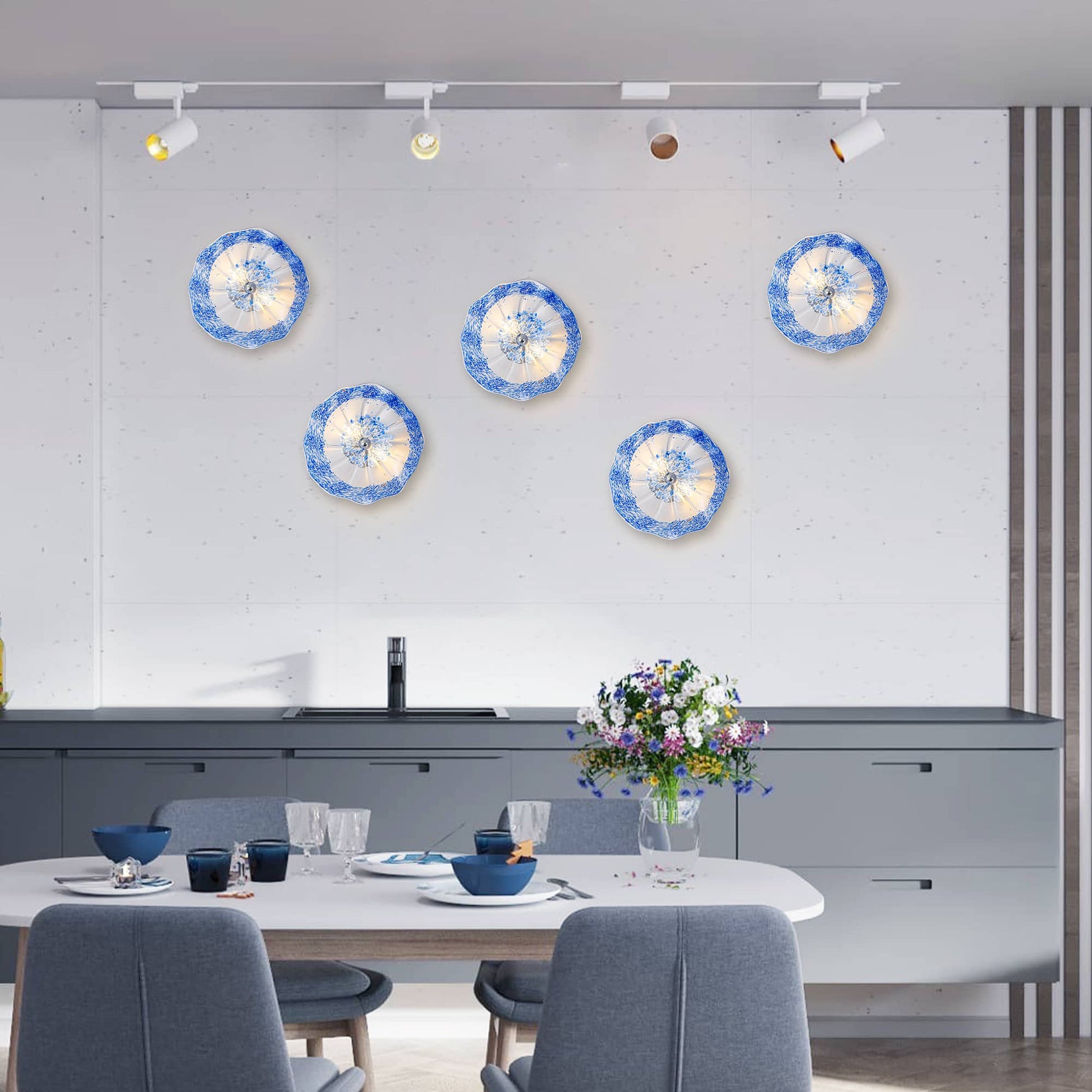 Decorative art glass wall plates in cobalt blue and white, arranged as a gallery wall installation.