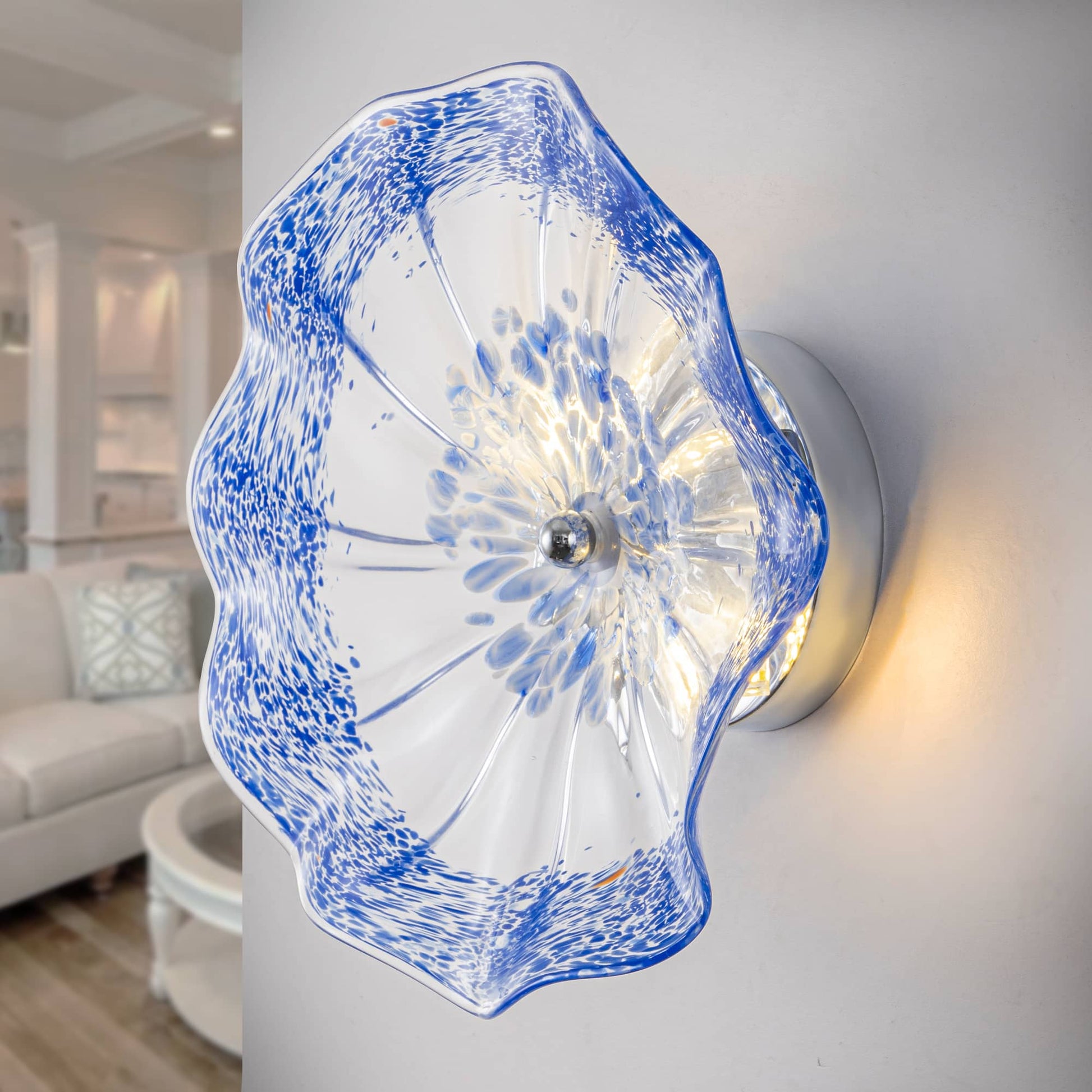 Close-up of hand-blown cobalt blue spotted Murano glass wall plate with warm LED backlight.