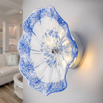 Close-up of hand-blown cobalt blue spotted Murano glass wall plate with warm LED backlight.