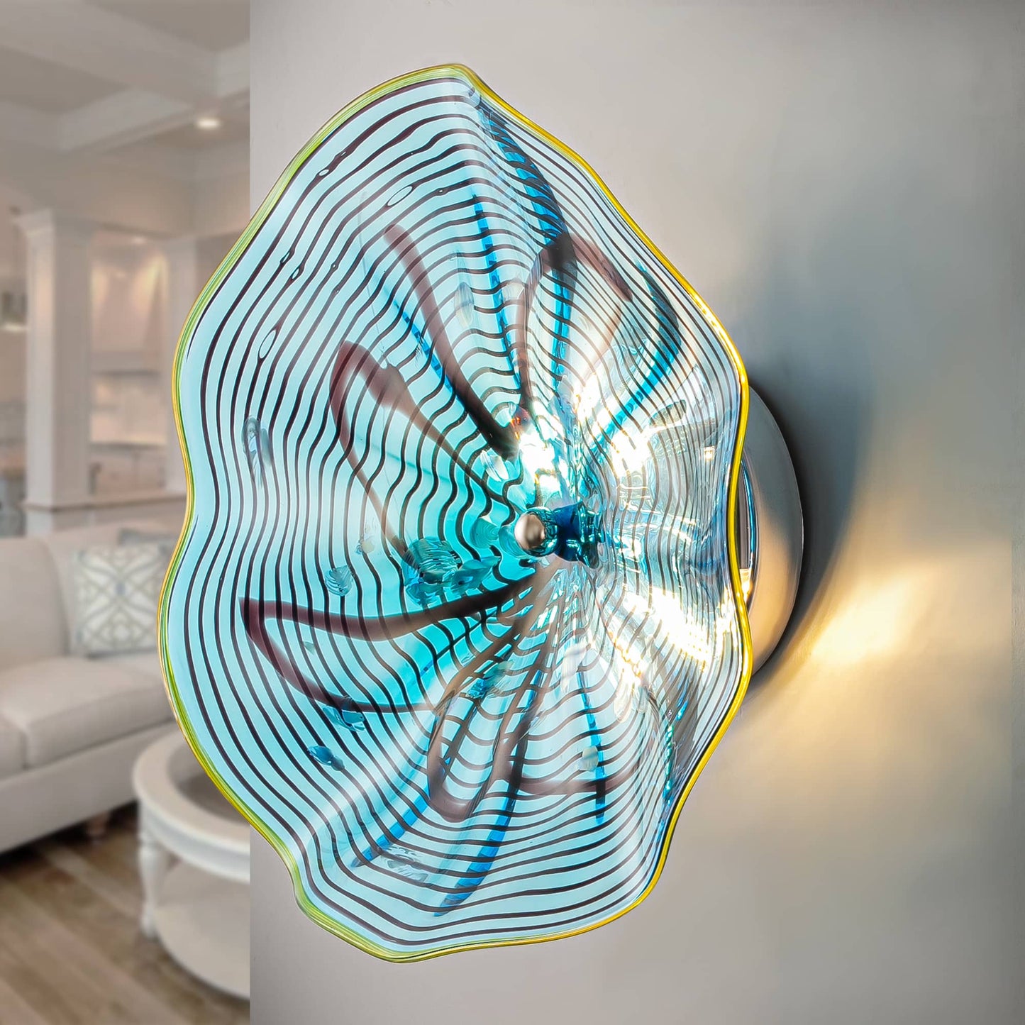 Side view of an illuminated aqua lotus glass wall lamp showing warm backlighting on a neutral wall.