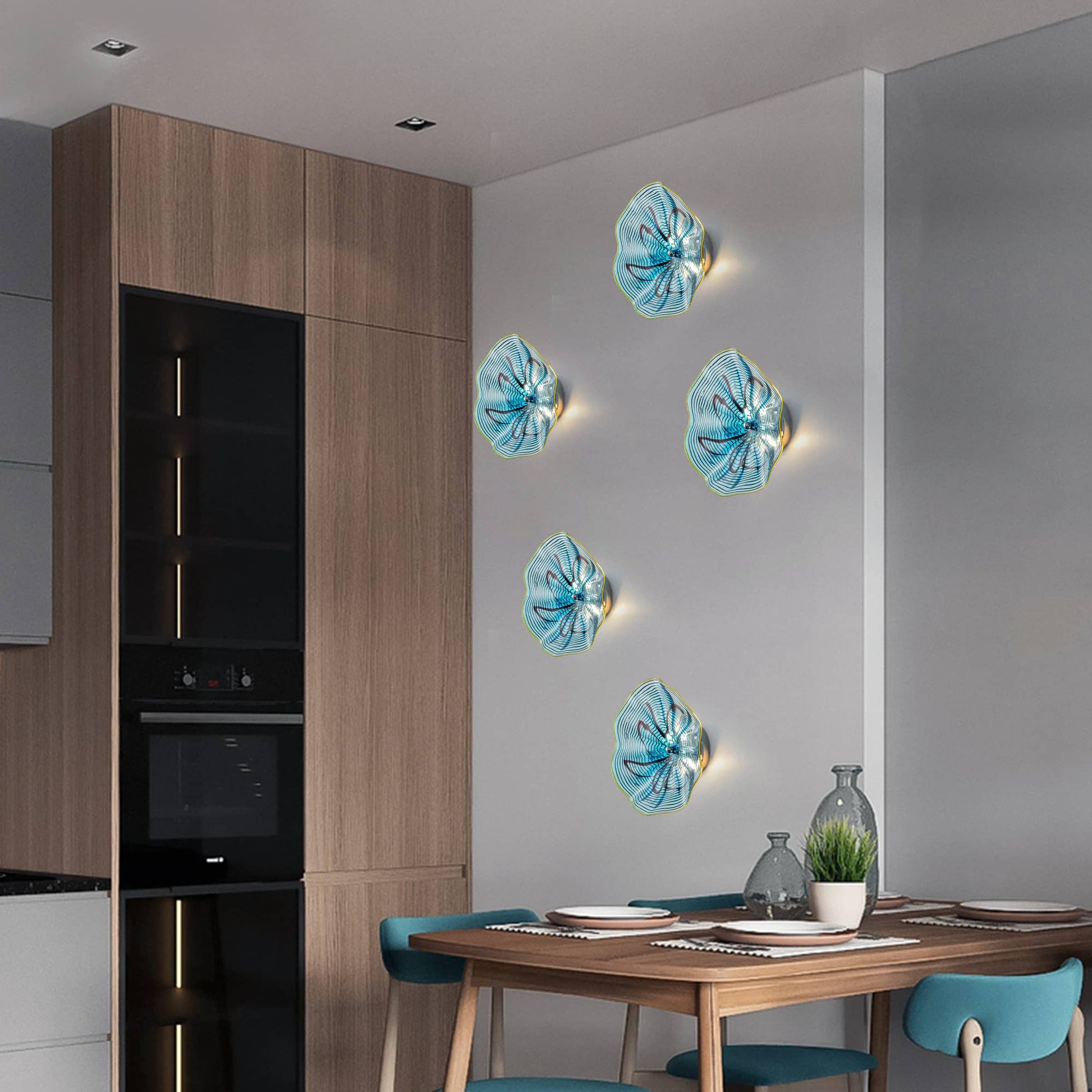 Trio of glowing aqua glass wall flowers installed in a modern kitchen area near dark cabinetry.