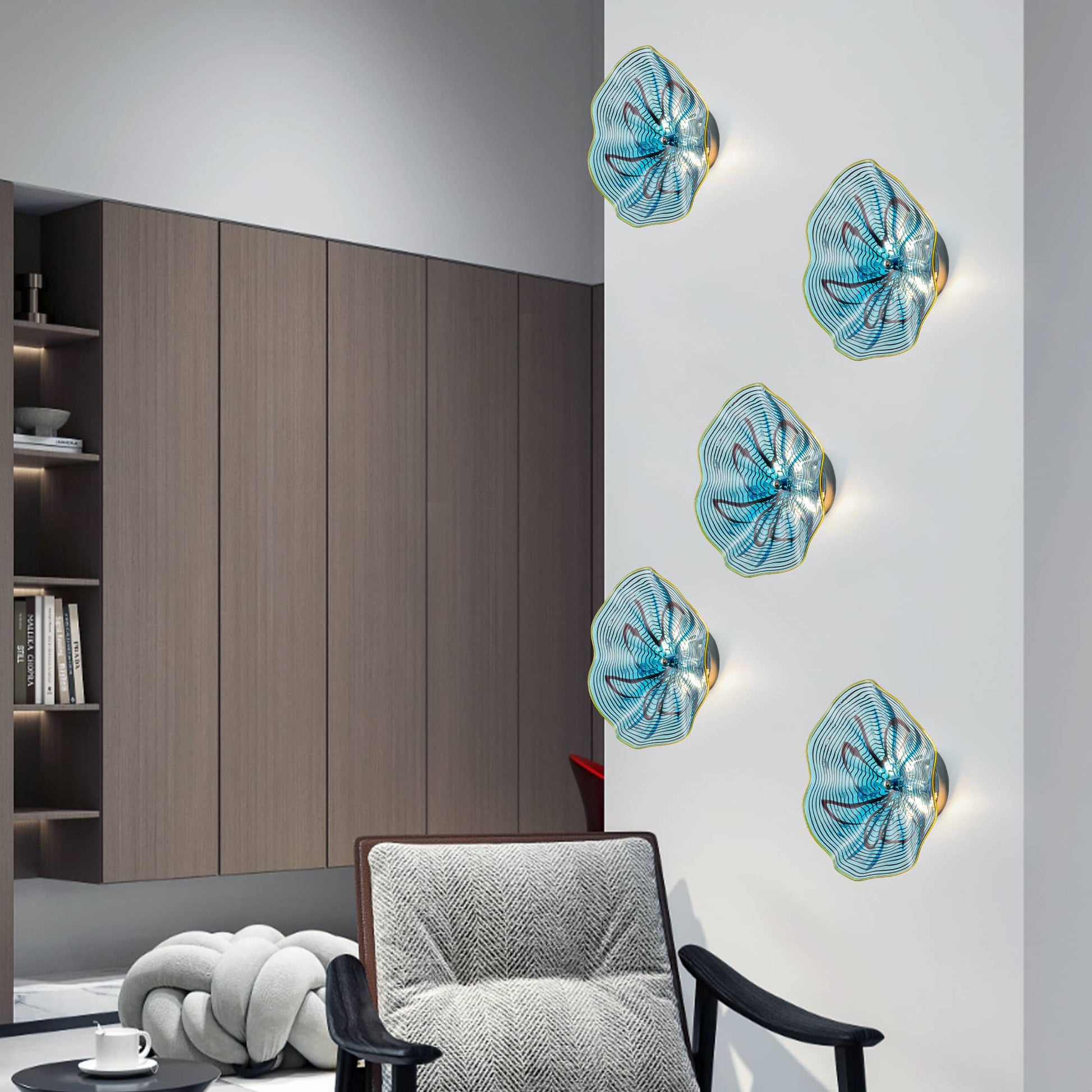 Three vertically arranged aqua glass LED sconces adding a touch of color to a modern gray-walled lounge.