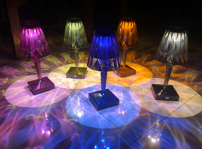 Group of modern colorful acrylic crystal table lamps with vibrant shadow projections.