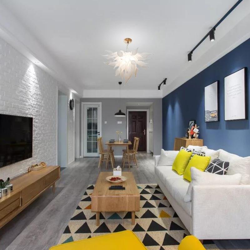 Modern open-plan living space with minimalist wooden decor, illuminated by a radiant white Arctic Petal artisan pendant light.
