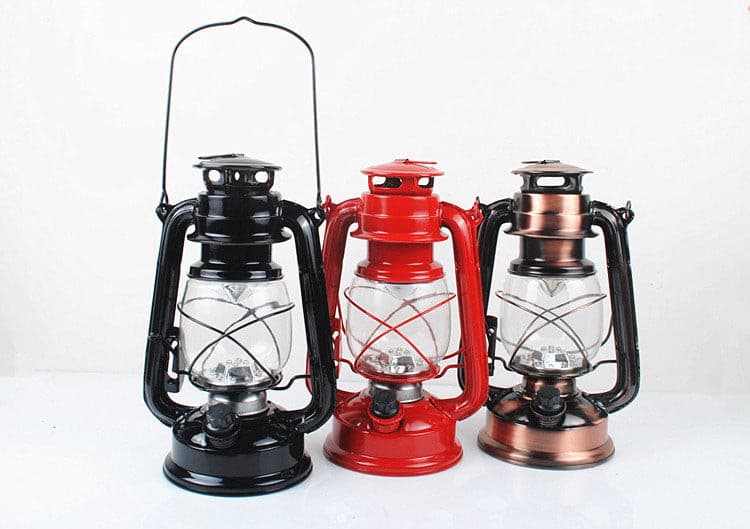 Trio of vintage LED lanterns in black, red, and antique copper finishes.
