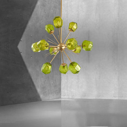 Artistic green glass chandelier showing the symmetrical metallic sphere and radiating gold rods in a monochrome setting.